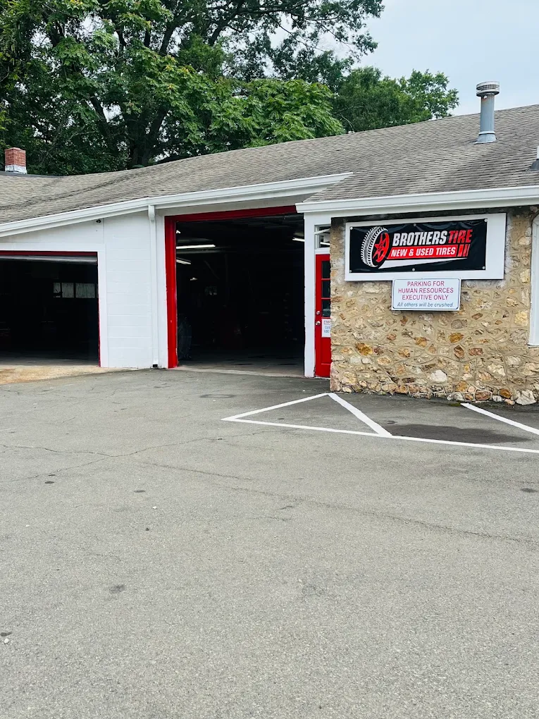 The Brothers Tire shop front on Hillsborough Rd, showing the open service bay and the shop's red-and-black sign.